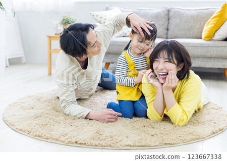 A close family lying on the floor in the living room 123667338