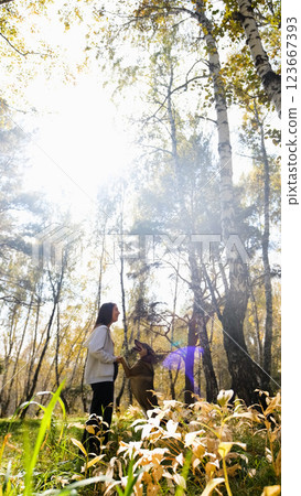 Young woman walking with a dog in an autumn forest 123667393