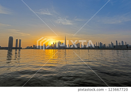 Panoramic view of Dubai skyline at sunset with Burj Khalifa and water reflections 123667720