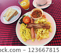 Vegan English Breakfast with Tofu Scramble, Sausage, Plant Based Bacon, Potatoes, Toast, and Orange 123667815