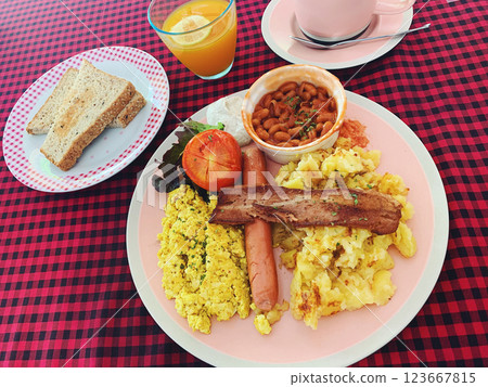 Vegan English Breakfast with Tofu Scramble, Sausage, Plant Based Bacon, Potatoes, Toast, and Orange 123667815