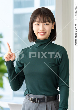 A smiling woman/businesswoman pointing with her index finger up A smiling woman/businesswoman pointing with her index finger up 123667828