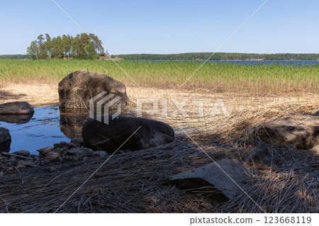 Granite stones lay on the lake coast. Monrepos Park Granite stones lay on the lake coast. Monrepos Park 123668119