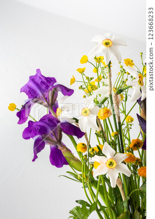 Bouquet of spring flowers, irises and yellow ranunculus with white daffodils Bouquet of spring flowers, irises and yellow ranunculus with white daffodils 123668233