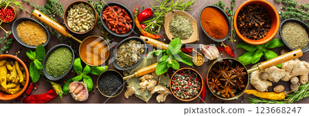 A rich palette of colorful spices and herbs, resting on a brown background, radiating freshness and an inviting aroma, perfect for gourmet inspiration, banner 123668247