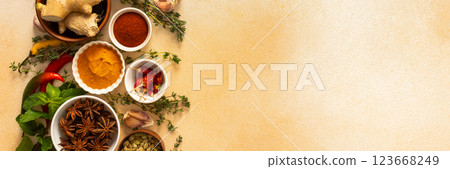 A warm display of spices and herbs on a beige background, each adding rich aromas and flavors, perfect for enhancing recipes, banner 123668249