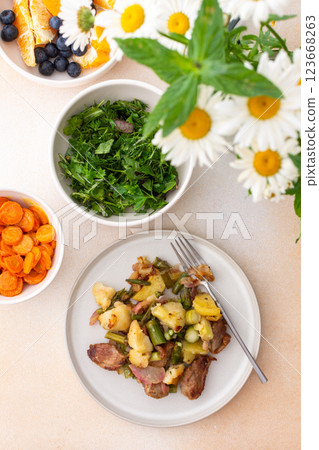 Stewed duck fillet with potatoes and asparagus and radishes, mixed salad of various greens, baked carrots in tahini sauce Stewed duck fillet with potatoes and asparagus and radishes, mixed salad of various greens, baked carrots in tahini sauce 123668263