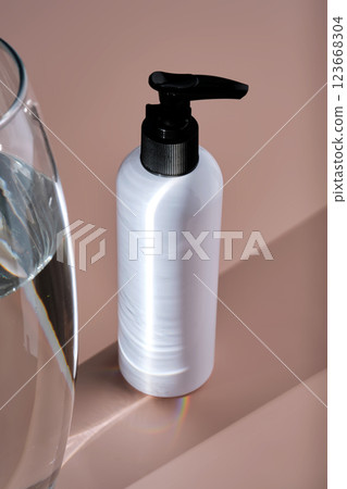 White bottles of bath product on a powdery pink background. White bottles of bath product on a powdery pink background. 123668304
