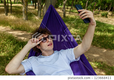 A young guy takes a selfie on the phone A young guy takes a selfie on the phone 123668411