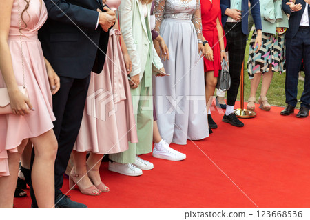 Smart prom guests stands on a red carpet Smart prom guests stands on a red carpet 123668536