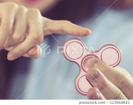 Person playing with fidget spinner Person playing with fidget spinner 123668681