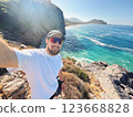 Man Taking Selfie on Rocky Cliff with Turquoise Sea View in Gazipasa Turkey on Sunny Day 123668828