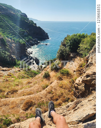 POV Person Sitting on Cliff Edge with Ocean View during Hiking Adventure in Gazipasa Turkey on Sunny 123668831