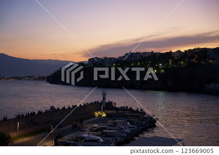 Antalya Turkey harbor at twilight with docked boats, cliffs, people by the sea Antalya Turkey harbor at twilight with docked boats, cliffs, people by the sea 123669005