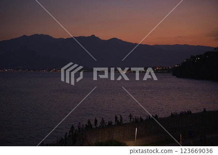 Antalya Turkey twilight coast with people relaxing by the sea and mountain view Antalya Turkey twilight coast with people relaxing by the sea and mountain view 123669036