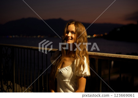 Woman at night in Antalya Turkey with sea and colorful twilight in background Woman at night in Antalya Turkey with sea and colorful twilight in background 123669061