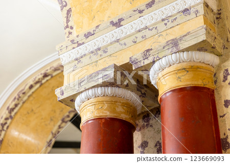 Red stone pillars with yellow white capitals are under ceiling 123669093