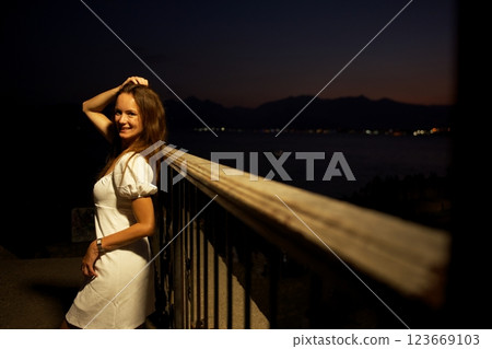 Smiling woman at night in Antalya Turkey with sea and twilight in background 123669103