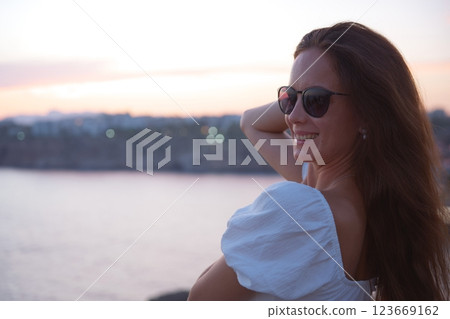 Smiling woman in sunglasses at seaside sunset in Antalya, Turkey Smiling woman in sunglasses at seaside sunset in Antalya, Turkey 123669162