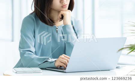 A woman/businesswoman thinking while looking at a computer screen A woman/businesswoman thinking while looking at a computer screen 123669236