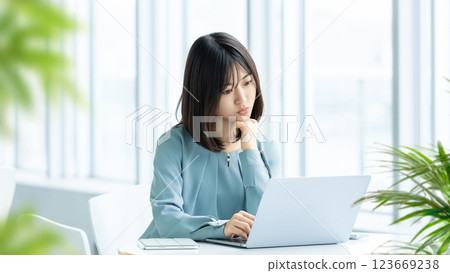 A woman/businesswoman thinking while looking at a computer screen A woman/businesswoman thinking while looking at a computer screen 123669238