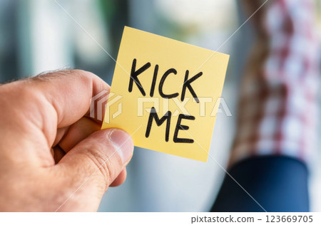 April fools concept with kick me note held in hand, blurred background 123669705