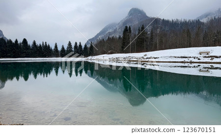 Serene Winter Lake with Mountain Reflections and Benches 123670151