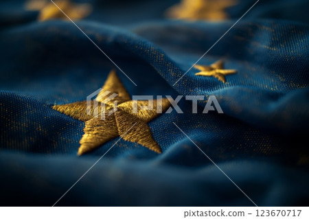 Closeup photo of a golden star embroidered on a blue flag, symbolizing patriotism and national pride in soft focus 123670717