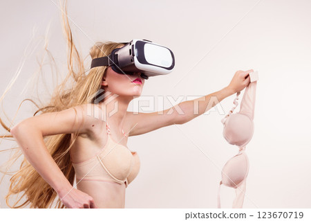 Girl in virtual reality goggles holds bra 123670719