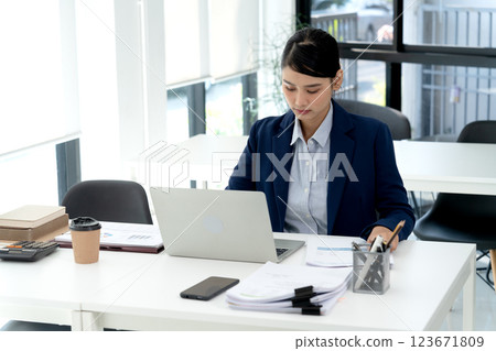 businesswoman Concentrating on work  looking at documents and laptop 123671809