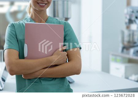 Woman scientist standing in hospital laboratory with paper folder in hands Woman scientist standing in hospital laboratory with paper folder in hands 123672028