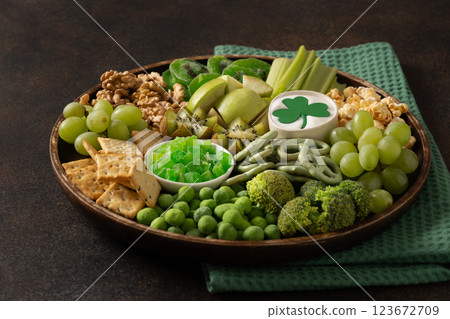 St Patricks day charcuterie board, shamrock and party decorations on brown background. DIY snack board. Close up. Copy space. 123672709