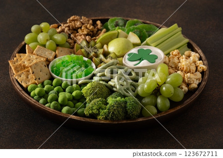 St Patricks day charcuterie board, shamrock and party decorations on brown background. Festive holiday appetizer for celebration. Close up. 123672711