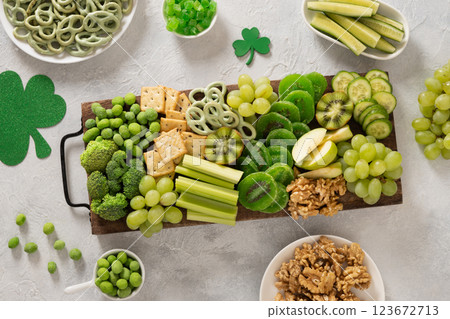 St. Patrick's Day Inspired Snacks charcuterie board with fresh vegetables decorated traditional green clover leaves on light background. Festive holiday appetizer. Top view St. Patrick's Day Inspired Snacks charcuterie board with fresh vegetables decorated traditional green clover leaves on light background. Festive holiday appetizer. Top view 123672713