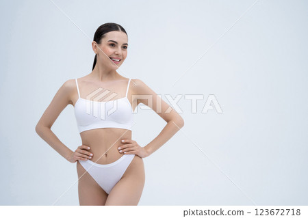 Brunette beautiful young woman in white lingerie posing and looking contented Brunette beautiful young woman in white lingerie posing and looking contented 123672718