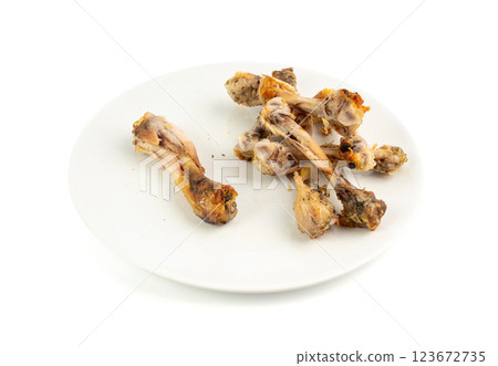 Chicken Leftovers, Unfinished Grilled Chicken on Dirty Plate Isolated, Meat Pieces and Bones after Dinner Chicken Leftovers, Unfinished Grilled Chicken on Dirty Plate Isolated, Meat Pieces and Bones after Dinner 123672735