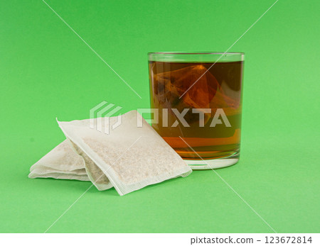 Herbal tea sachet in glass, hot water with chamomile and Hypericum or St. John's wort teabag 123672814