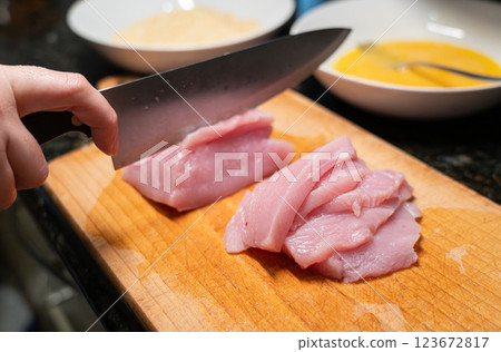 Raw turkey fillet slicing for nuggets or escalope, cut meat with kitchen knife, homemade schnitzel Raw turkey fillet slicing for nuggets or escalope, cut meat with kitchen knife, homemade schnitzel 123672817