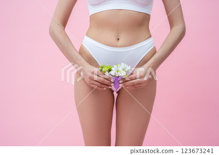 Unrecognizable woman holding menstrual eco-friendly reusable silicone cup with flowers Unrecognizable woman holding menstrual eco-friendly reusable silicone cup with flowers 123673241