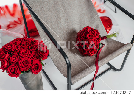 metal chair with gray fabric and red roses with love inscriptions. photo zone for valentine's day 123673267