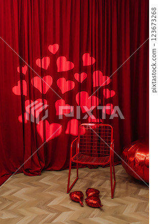 red iron chair on the background of red fabric with hearts. photo zone for lovers red iron chair on the background of red fabric with hearts. photo zone for lovers 123673268
