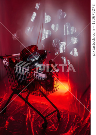 supermarket trolley full of foil balloons on red background. creative photo zone with hearts 123673278
