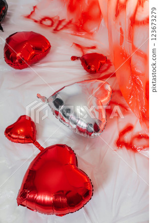 foil heart shaped balloons on white floor. photo zone for love day in photo studio foil heart shaped balloons on white floor. photo zone for love day in photo studio 123673279