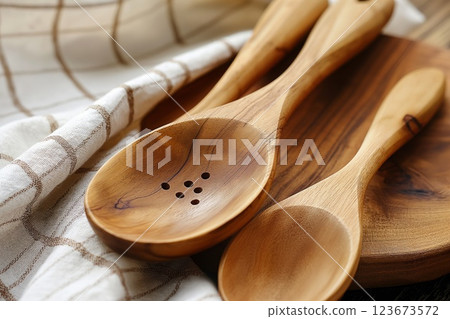 Closeup photo spotlighting a set of wooden spoons on a linen cloth, blending functionality with a touch of classic kitchen elegance 123673572