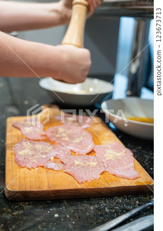 Peppering of tenderized meat for schnitzel Peppering of tenderized meat for schnitzel 123673713