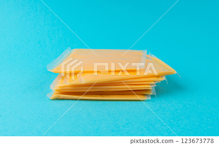 American cheese, processed cheese slice, wrapped thin yellow cheddar in a plastic package American cheese, processed cheese slice, wrapped thin yellow cheddar in a plastic package 123673778