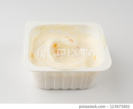 Yogurt cup isolated, yoghurt with orange fruits pieces in plastic pot, milk pudding container 123673802