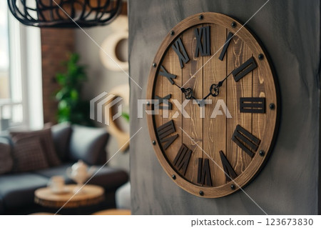 Classic wooden wall clock with roman numerals, providing a timeless accent to a modern living room decor 123673830