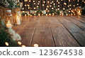 Burning candles and string lights creating warm atmosphere on wooden floor 123674538