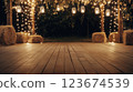 Wooden floor with hay bales and string lights creating a festive atmosphere 123674539